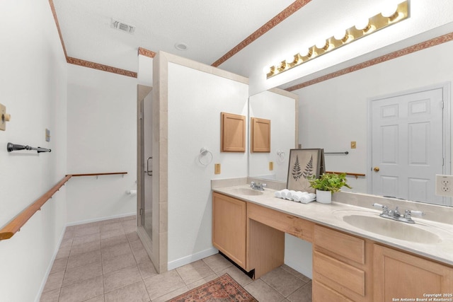 bathroom with double vanity, a stall shower, a sink, and visible vents