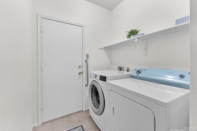 clothes washing area with light tile patterned floors, laundry area, and separate washer and dryer