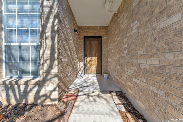 doorway to property featuring brick siding