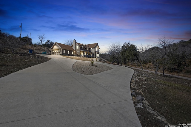 view of front of property featuring curved driveway and a chimney