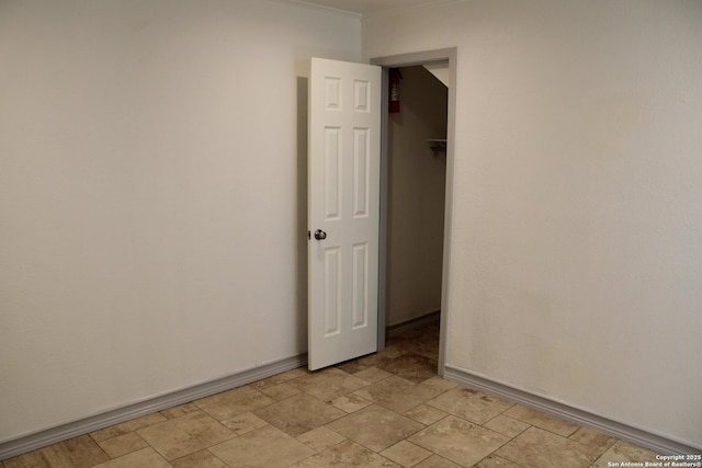 empty room with stone finish flooring and baseboards