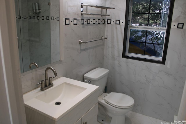 bathroom with toilet, marble finish floor, walk in shower, and vanity