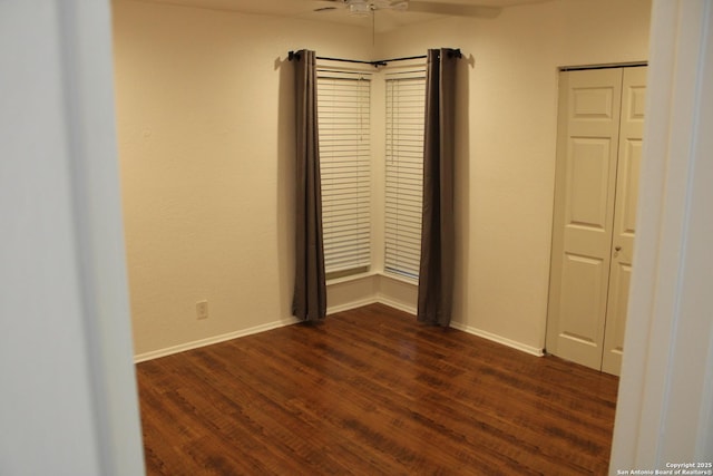 unfurnished room featuring ceiling fan, dark wood finished floors, and baseboards