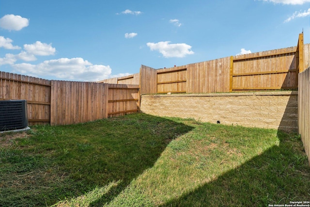 view of yard with central AC and a fenced backyard