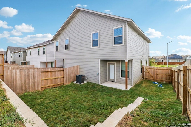 back of property with a fenced backyard, central air condition unit, a lawn, a residential view, and a patio area