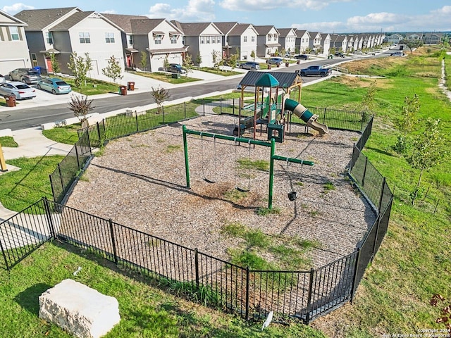 view of community with a residential view, playground community, fence, and a lawn