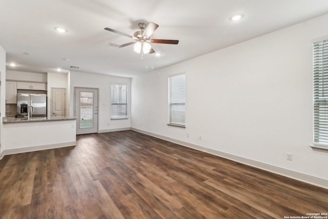 unfurnished living room featuring recessed lighting, dark wood-type flooring, a sink, ceiling fan, and baseboards
