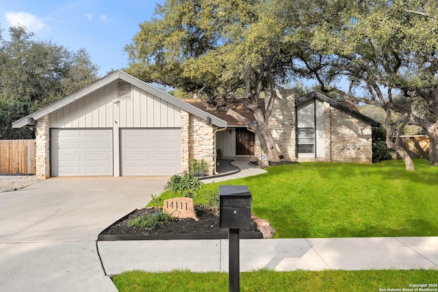 mid-century modern home with a garage, fence, driveway, stone siding, and a front yard