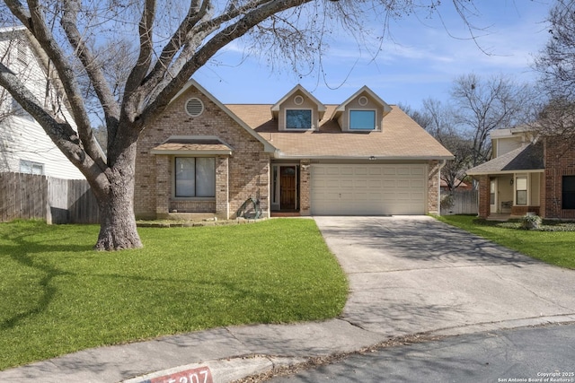 view of front of home with an attached garage, a front yard, fence, and brick siding