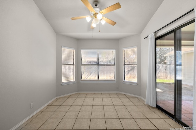 unfurnished room with light tile patterned floors, a ceiling fan, and baseboards