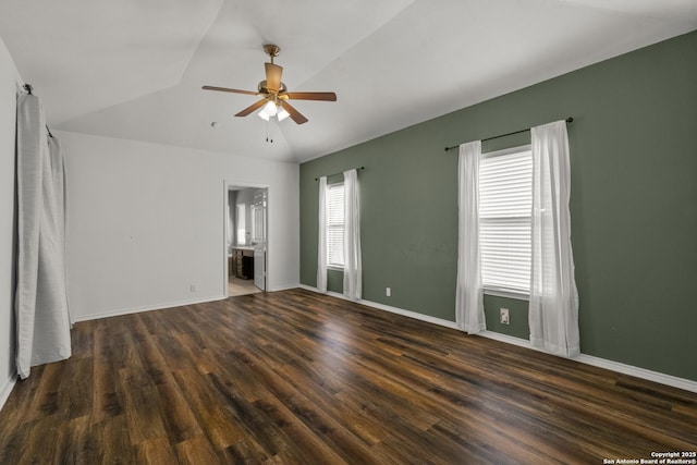 spare room with wood finished floors, vaulted ceiling, baseboards, and ceiling fan