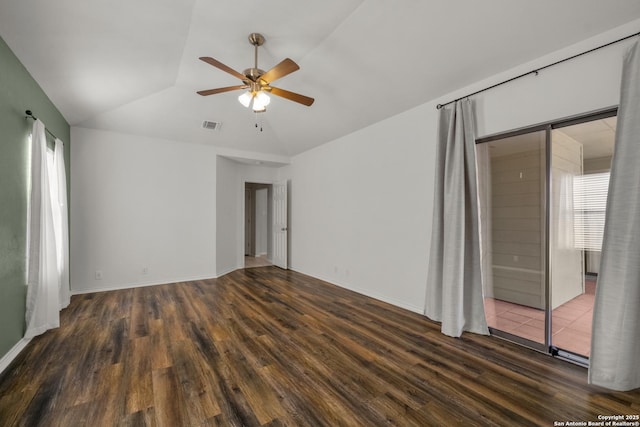 empty room with a healthy amount of sunlight, visible vents, vaulted ceiling, and wood finished floors