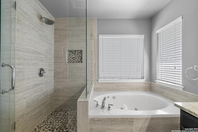 full bath featuring a stall shower, a tub with jets, and vanity