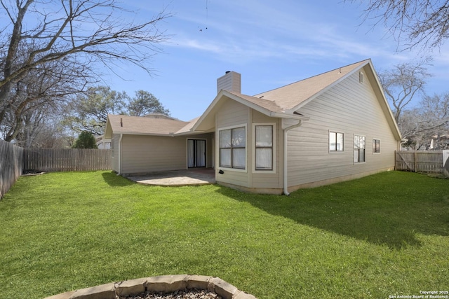 back of property featuring a patio area, a fenced backyard, a chimney, and a lawn