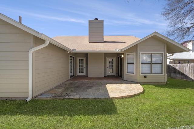 rear view of property featuring a patio, fence, a yard, roof with shingles, and a chimney