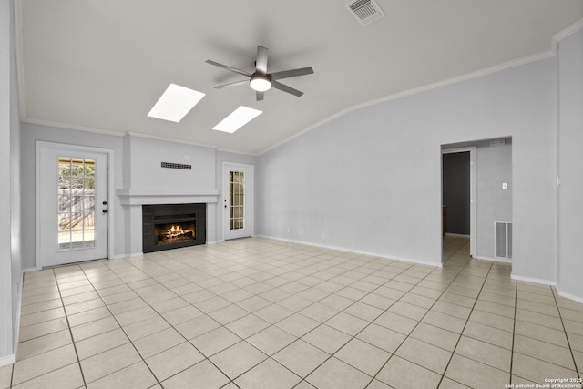 unfurnished living room with vaulted ceiling with skylight, a tiled fireplace, visible vents, and crown molding