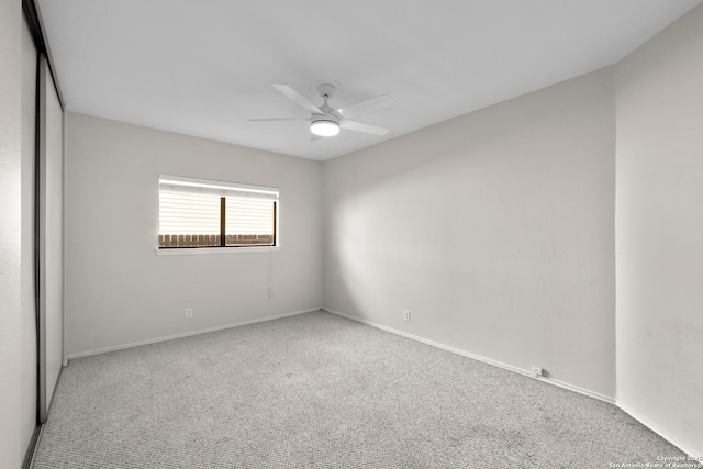 spare room featuring carpet, a ceiling fan, and baseboards