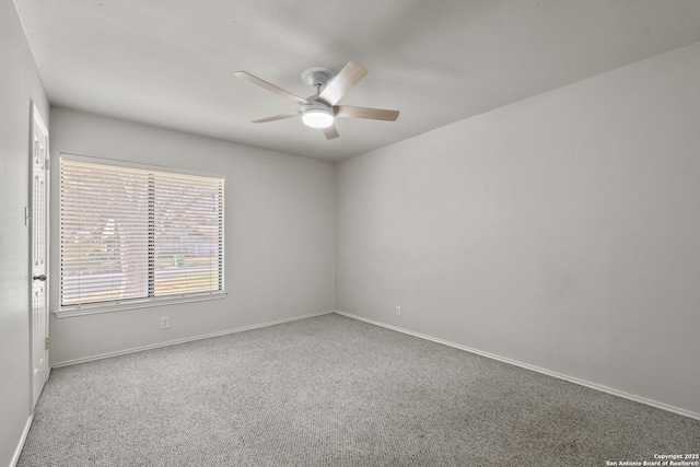 empty room with carpet flooring, ceiling fan, and baseboards