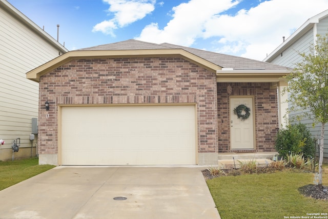 view of front facade with a front yard, concrete driveway, brick siding, and an attached garage