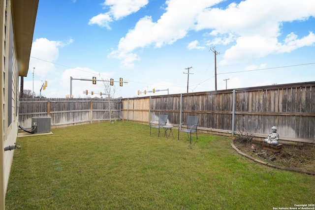 view of yard with a fenced backyard and central air condition unit