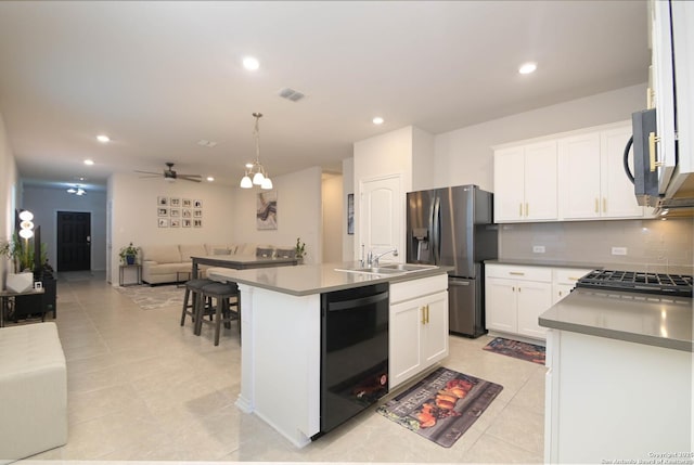 kitchen featuring tasteful backsplash, dishwasher, open floor plan, stainless steel refrigerator with ice dispenser, and a sink