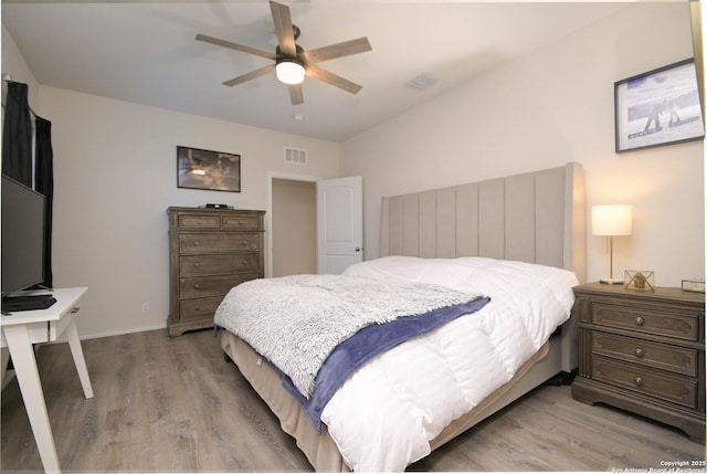 bedroom featuring light wood-style flooring, visible vents, and a ceiling fan