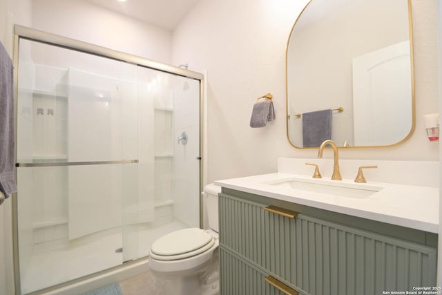 bathroom with toilet, a shower stall, and vanity