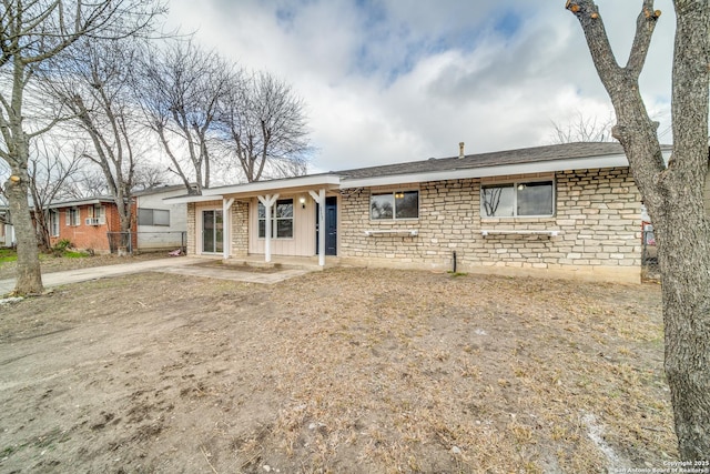 ranch-style house with stone siding and board and batten siding