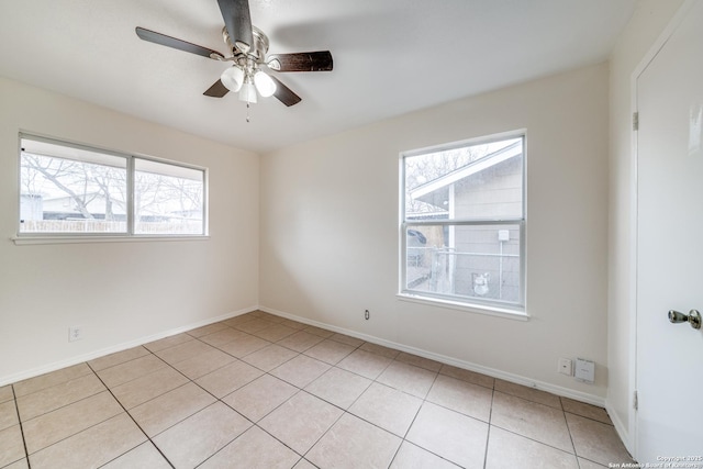 spare room with ceiling fan, baseboards, and light tile patterned floors