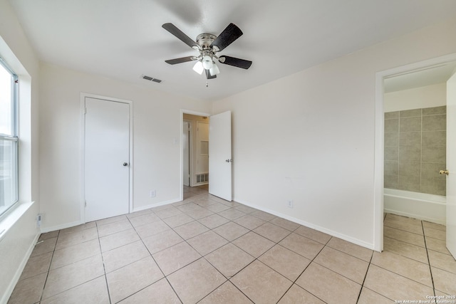 unfurnished bedroom featuring baseboards, visible vents, ceiling fan, and light tile patterned flooring