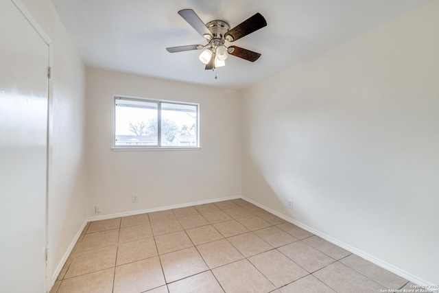 spare room featuring ceiling fan, baseboards, and light tile patterned floors