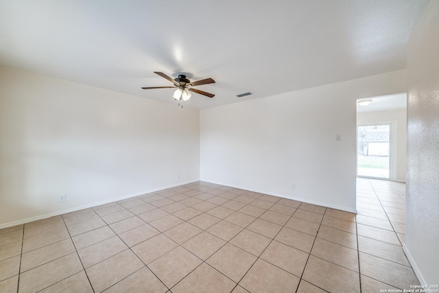 spare room with a ceiling fan, visible vents, baseboards, and light tile patterned floors