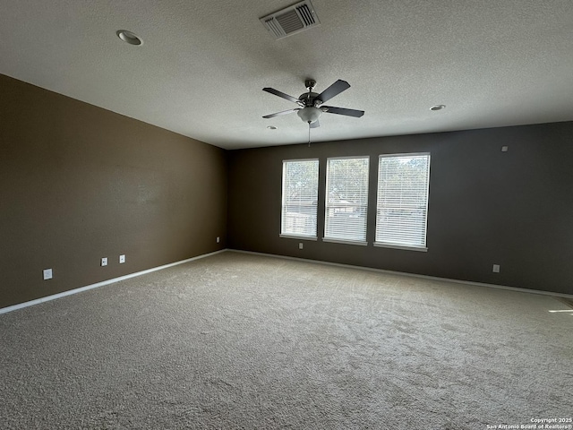 carpeted spare room with visible vents, ceiling fan, a textured ceiling, and baseboards