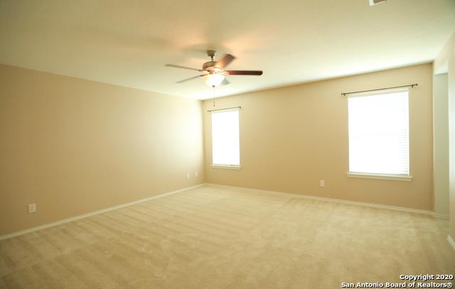 empty room with light colored carpet, ceiling fan, and baseboards