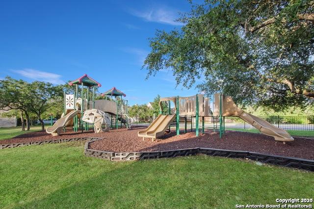 community play area featuring a lawn and fence