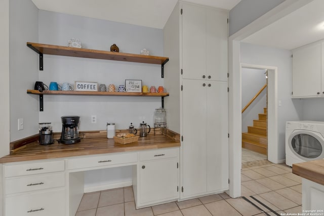 bar with stairs, washer / clothes dryer, and light tile patterned floors