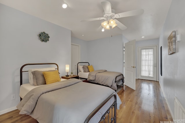 bedroom with light wood-style flooring, a ceiling fan, visible vents, and baseboards