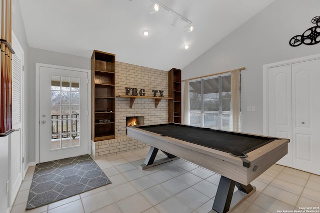 recreation room featuring a fireplace, pool table, light tile patterned flooring, track lighting, and high vaulted ceiling