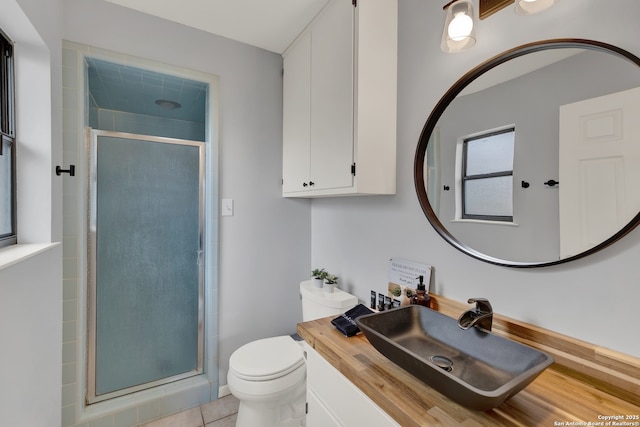 full bath featuring a stall shower, vanity, toilet, and tile patterned floors