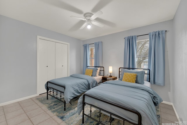 tiled bedroom featuring a closet, ceiling fan, and baseboards