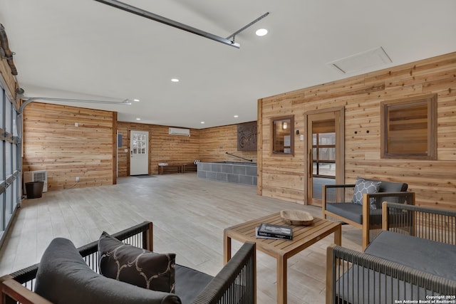 living room featuring a garage and wood walls