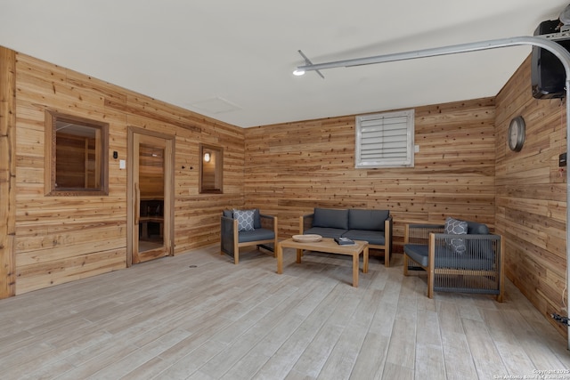 unfurnished room with light wood-type flooring and wooden walls