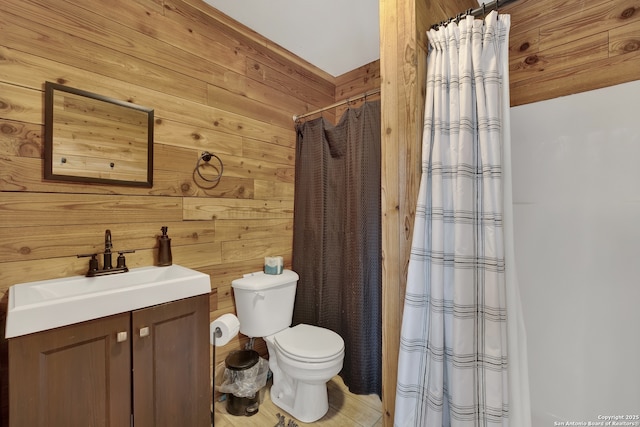 bathroom featuring toilet, wood walls, curtained shower, and vanity