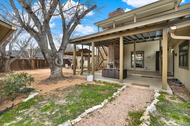 view of yard featuring a patio area, fence, and stairs