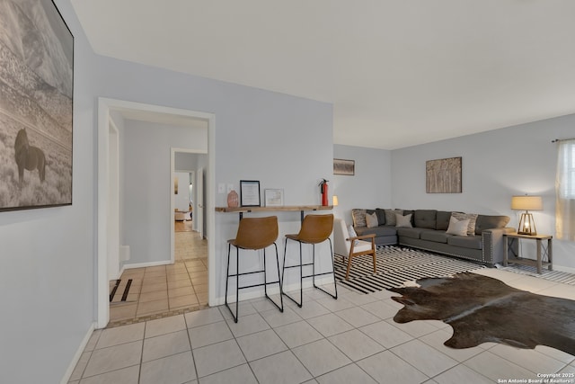 living area with baseboards and light tile patterned floors