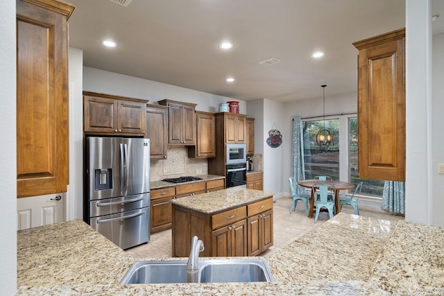 kitchen featuring light stone counters, light tile patterned flooring, a sink, decorative backsplash, and black appliances