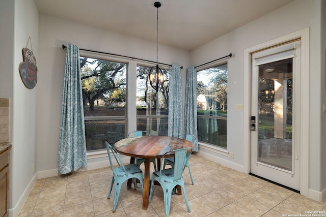 dining space featuring a chandelier, baseboards, and light tile patterned floors