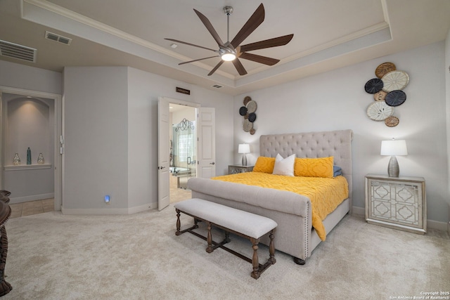 bedroom with a raised ceiling, light colored carpet, crown molding, and visible vents