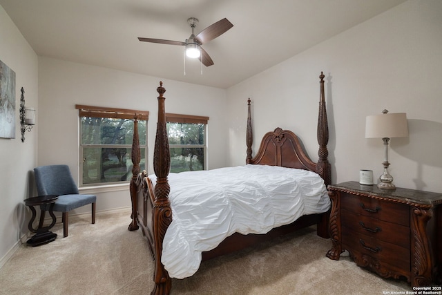 bedroom with a ceiling fan, light colored carpet, and baseboards