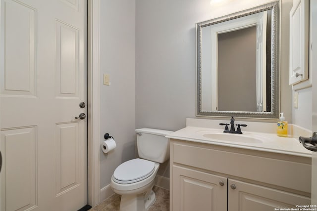 bathroom with toilet, tile patterned floors, baseboards, and vanity